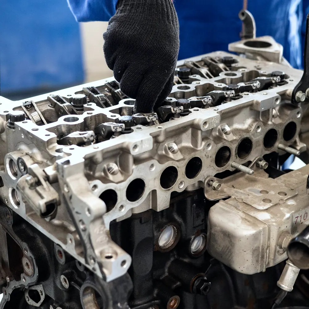 Gloved hand working on an open engine cylinder head
